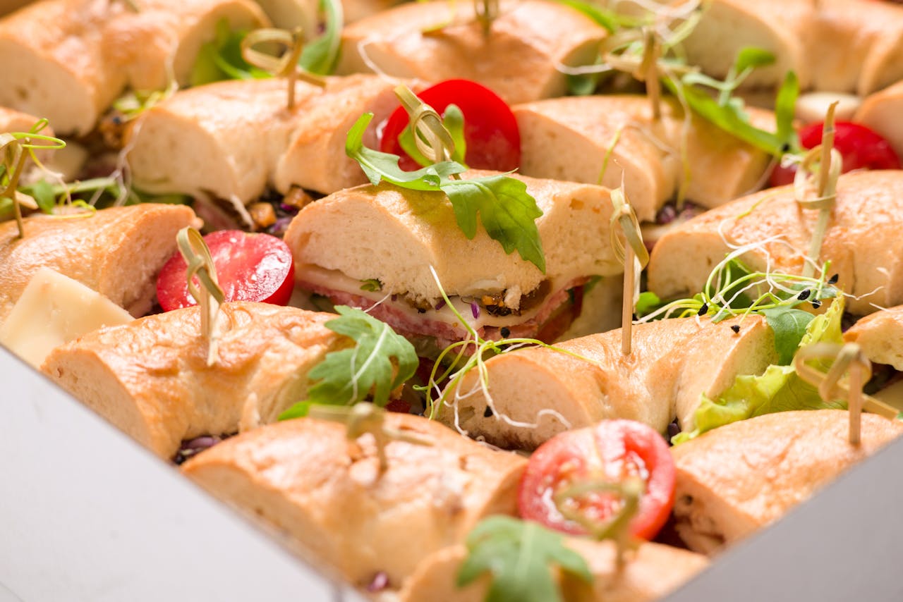 Delicious assortment of sandwiches with fresh vegetables and cheese, perfect for catering events.