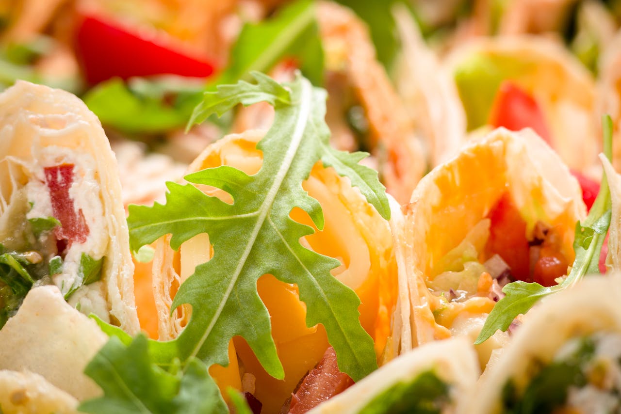 Vibrant close-up of fresh vegetable wraps garnished with arugula leaves.